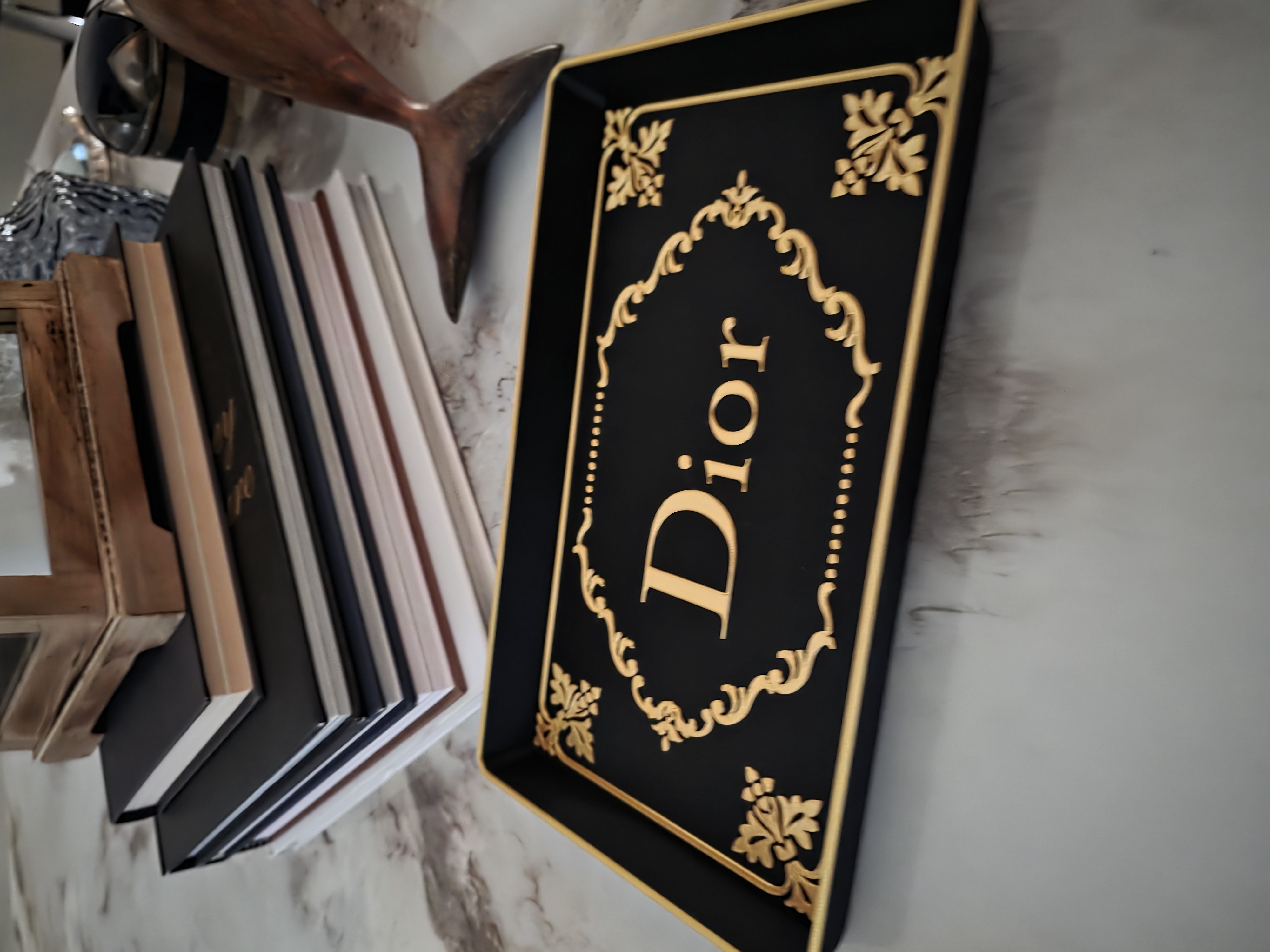 Ornate black and gold statement tray styled on a marble surface